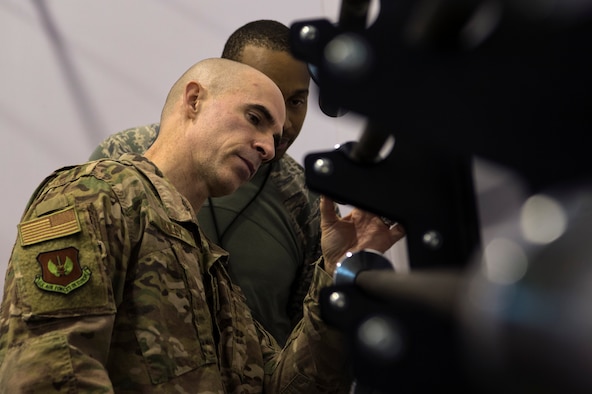 U.S. Air Force Col. Jason Bailey, 52nd Fighter Wing commander, front, tours the fitness center at Ghedi Air Base, Italy, Nov. 15, 2018. Senior Airman Daniel Coleman, 704th Munitions Support Squadron fitness specialist, back, demonstrated the center's new equipment. Leadership from Spangdahlem Air Base, Germany, visited the 704th MUNSS to support and connect with Airmen. (U.S. Air Force photo by Airman 1st Class Valerie Seelye)