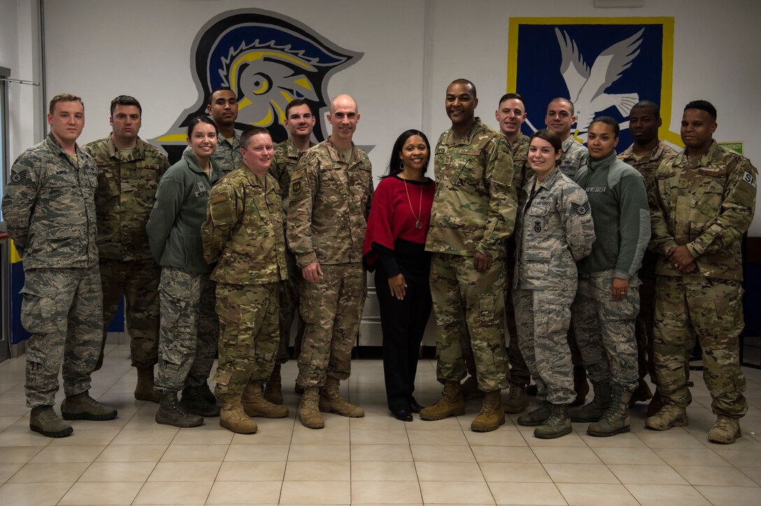 U.S. Air Force Col. Jason Bailey, 52nd Fighter Wing commander, center left, Chief Master Sgt. Alvin Dyer, 52nd FW command chief, center right, and his wife, Tanquer Dyer, center, pose for a photo with 704th Munitions Support Squadron Airmen at Ghedi Air Base, Italy, Nov. 15, 2018. Spangdahlem Air Base leadership visited the 704th MUNSS to support Airmen and learn base functions. Mrs. Dyer met and connected with spouses to encourage a family atmosphere between geographically separated units. (U.S. Air Force photo by Airman 1st Class Valerie Seelye)