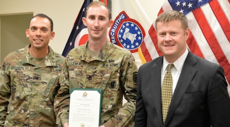 Three men, two Soldiers and one in suit.