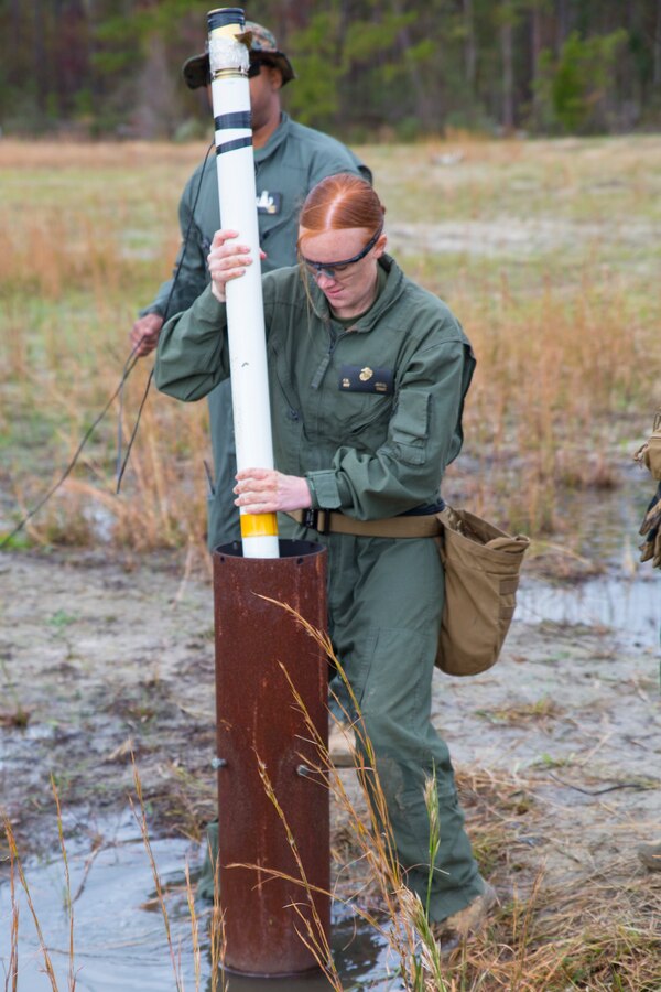 U.S. Marine Corps Sgt. Courtney Jewel, an Explosive Ordnance Disposal technician, places a 2 1/2 inch rocket into a tube during a static-fire range operation at Marine Corps Air Station Cherry Point, N.C., Nov. 14, 2018. In total, six rocket engines were used during the EOD annual training exercise. During the training, EOD technicians removed explosives from the rockets, allowing them to be used safely in future demonstrations. In addition to the annual training, the Marines also conduct live-fire and static-fire range operations on a bi-weekly to monthly basis. Jewel is assigned to Headquarters and Headquarters Squadron. (U.S. Marine Corps photo by Lance Cpl. Andrew King)