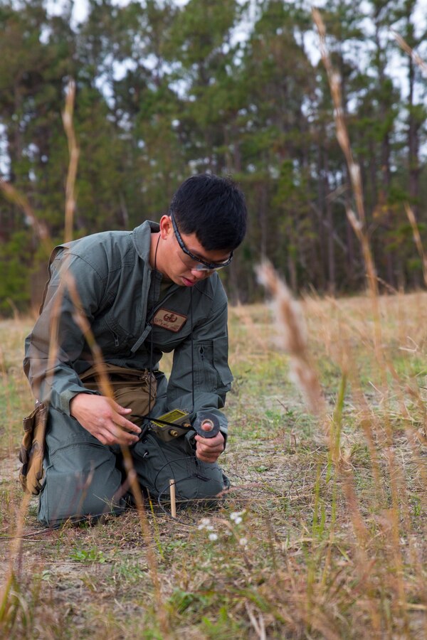 U.S. Marine Corps Sgt. Allen Luo,an Explosive Ordnance Disposal technician, wraps an ignition wire in electrical tape during a static-fire range operation at Marine Corps Air Station Cherry Point, N.C., Nov. 14, 2018. In total, six rocket engines were used during the EOD annual training exercise. During the training, EOD technicians removed explosives from the rockets, allowing them to be used safely in future demonstrations. In addition to the annual training, the Marines also conduct live-fire and static-fire range operations on a bi-weekly to monthly basis. Luo is assigned to Marine Wing Support Squadron 271, Marine Wing Support Group 27, 2nd Marine Aircraft Wing. (U.S. Marine Corps photo by Lance Cpl. Andrew King)