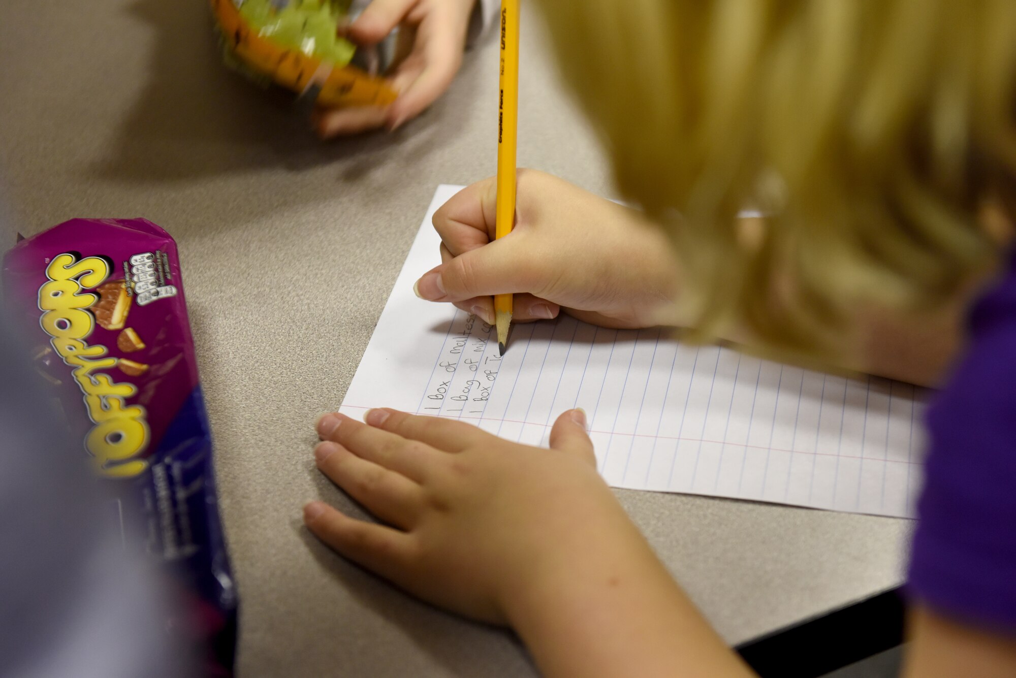 A student from Liberty Intermediate School writes a packing list for a care package at Royal Air Force Lakenheath, England, Nov. 13, 2018. Students from the National Elementary Honors Society and Continuous School Improvement juniors worked together to create care packages for deployed Liberty Wing Firefighter and Security Forces Airmen. (U.S. Air Force photo by Senior Airman John A. Crawford)