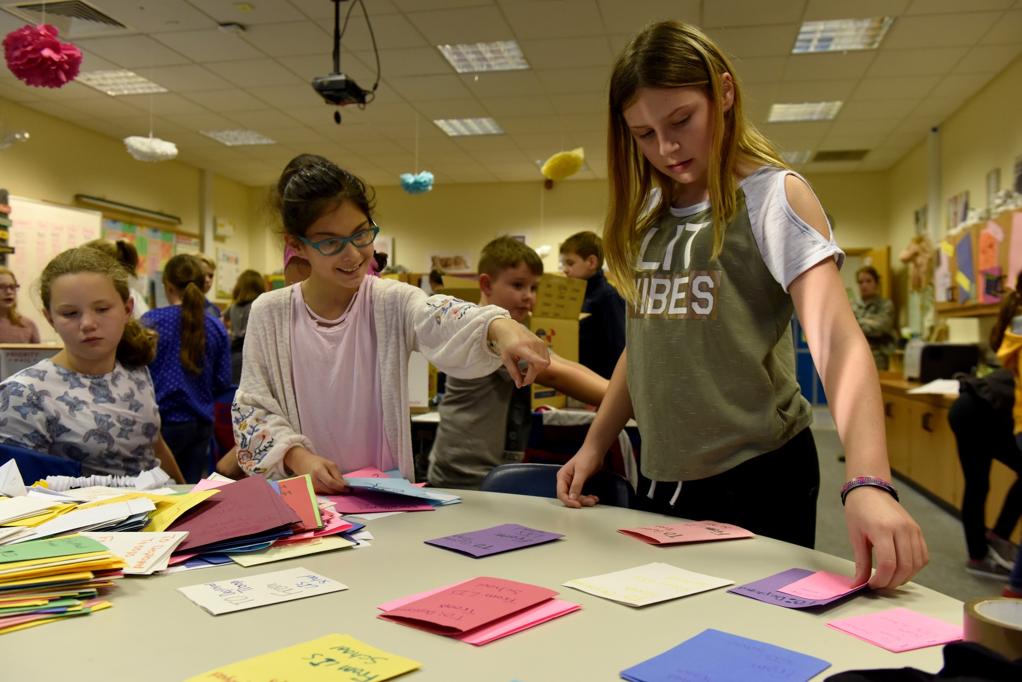 Students from Liberty Intermediate School sort cards for a care package at Royal Air Force Lakenheath, England, Nov. 13, 2018. Students from the National Elementary Honors Society and Continuous School Improvement juniors wrote letters of support and included them in care packages for deployed Liberty Wing firefighter and security forces members. (U.S. Air Force photo by Senior Airman John A. Crawford)