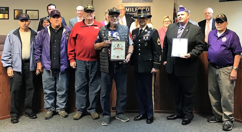 Twelve veterans and a Soldier in uniform at induction ceremony.