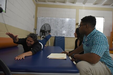 U.S. Army Spc. Devyn Leslie, Medical Element physical therapy technician helps guide his patient through exercises at a clinic in Comayagua, Nov. 8, 2018.