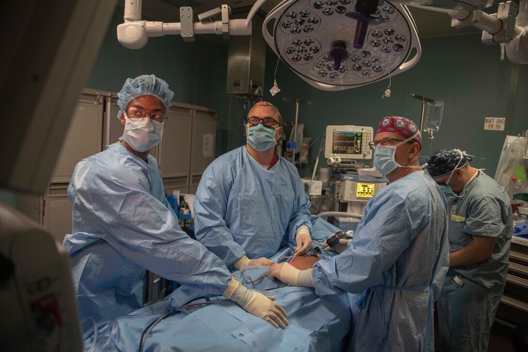 Medical personnel perform abdominal surgery on a patient to repair a hernia in the operating room aboard the hospital ship USNS Comfort (T-AH 20).