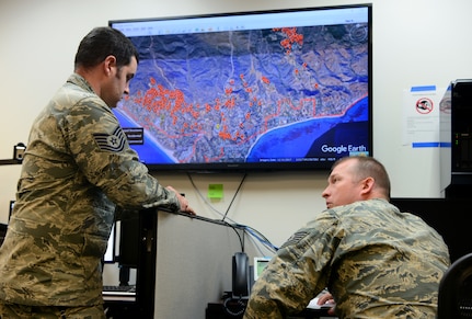 Tech. Sgt. Roy Davis and Staff Sgt. Matt Lemaire, 234th Intelligence Squadron intelligence analysts, sit on a conference call with various civilian and military agencies regarding the California wildfires Nov. 14, 2018, at Beale Air Force Base, Calif. The 234th IS Airmen are providing aerial imagery support to agencies battling the Camp and Woolsey Fires.