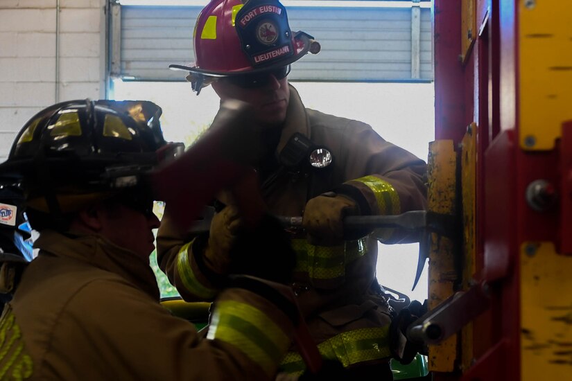 Brandon Young, Fort Eustis Fire Department firefighter, uses an axe to hammer a prying tool between the frame and the door to make it open easier at the Newport News Fire Department in Newport News, Virginia, Nov. 16, 2018. Firefighters have many tools that can assist in force entry like the Wide-ADZ Pro Bar, an axe and a hydraulic forcible entry tool known as the “Jaws of Life”. (U.S. Air Force photo by Senior Airman Derek Seifert)