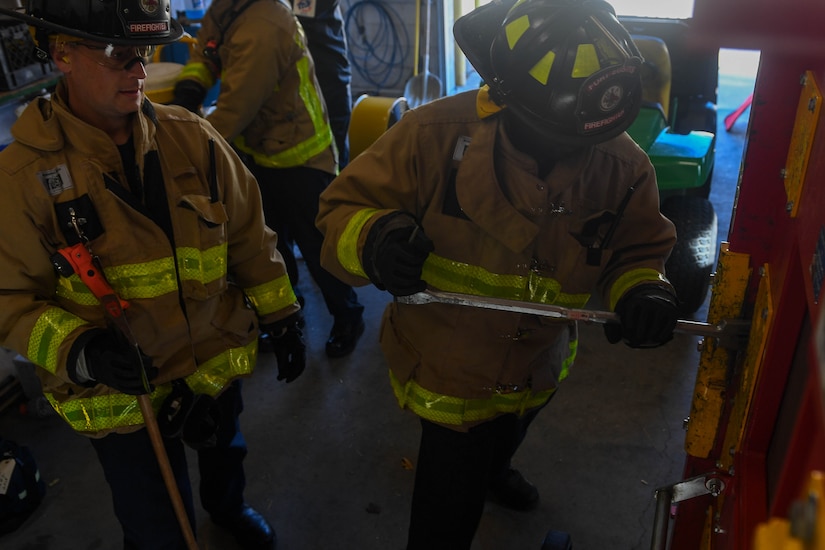 Brian Yohn and Kirkie Hampton, Fort Eustis firefighters, forcibly open a door during forced entry refresher training at the Newport News Fire Department in Newport News, Virginia, Nov. 16, 2018. The Fort Eustis firefighters conducted forcible entry training to become more familiar and comfortable in the event they are needed. (U.S. Air Force photo by Senior Airman Derek Seifert)