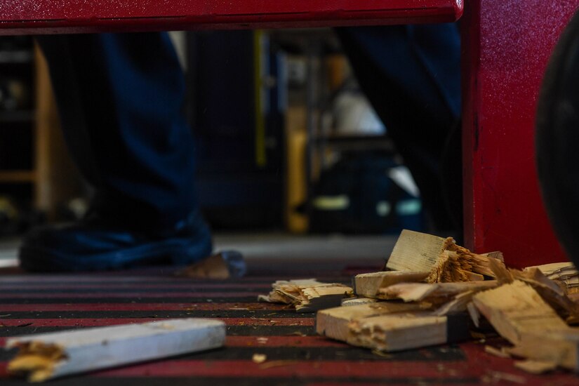 Pieces of broken wood lay on the ground after Fort Eustis Fire Department firefighters receive forced entry refresher training at the Newport News Fire Department in Newport News, Virginia, Nov. 16, 2018. The wood planks were used as door locks and depending on the width and dryness of the wood, presented a different challenge each time the firefighters forcibly opened the door. (U.S Air Force photo by Senior Airman Derek Seifert)