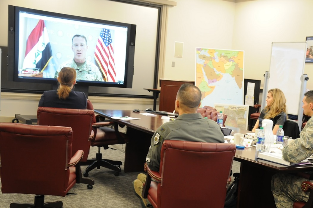 Air Force leadership virtually briefing a room of four individuals around a conference table