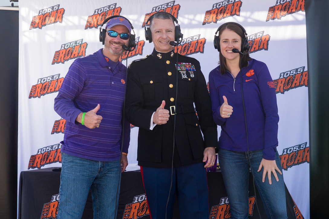 Col. William C. Gray, commanding officer of 6th Marine Corps District, poses for a picture with Ben Milstead and Kelly Glamlich, radio broadcasters for WCCP 105.5 the Roar, during a radio show before a Clemson University veteran's appreciation football game in Clemson, South Carolina, Nov. 17, 2018. Clemson University faced off against Duke University during the game. (U.S. Marine Corps photo by Sgt. Jorge A. Rosales)