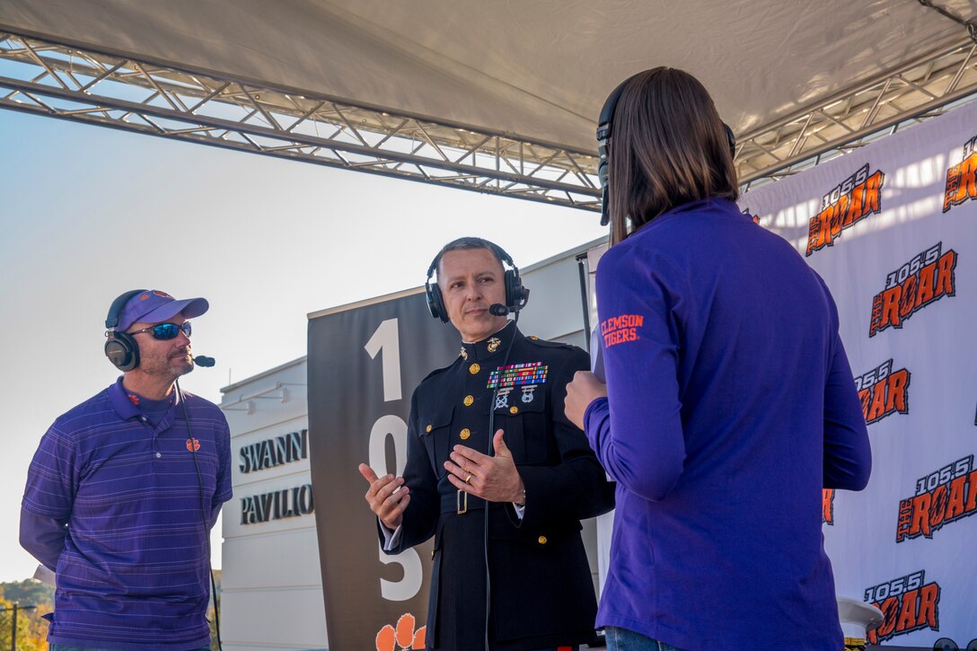 Col. William C. Gray, commanding officer of 6th Marine Corps District, speaks with Ben Milstead and Kelly Glamlich, radio broadcasters for WCCP 105.5 the Roar, during a radio show before a veteran's appreciation football game in Clemson, South Carolina, Nov. 17, 2018. (U.S. Marine Corps photo by Sgt. Jorge A. Rosales)