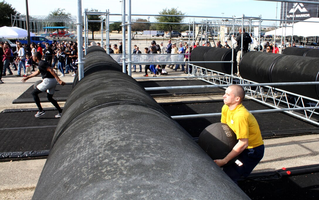 Navy Seaman Drew Fast crouches before throwing a medicine ball over the first obstacle of the proving rig during the first Inter-service Alpha Warrior Final Battle Nov. 17, 2018, Retama Park, Selma, Texas. (U.S. Air Force photo by Debbie Aragon)