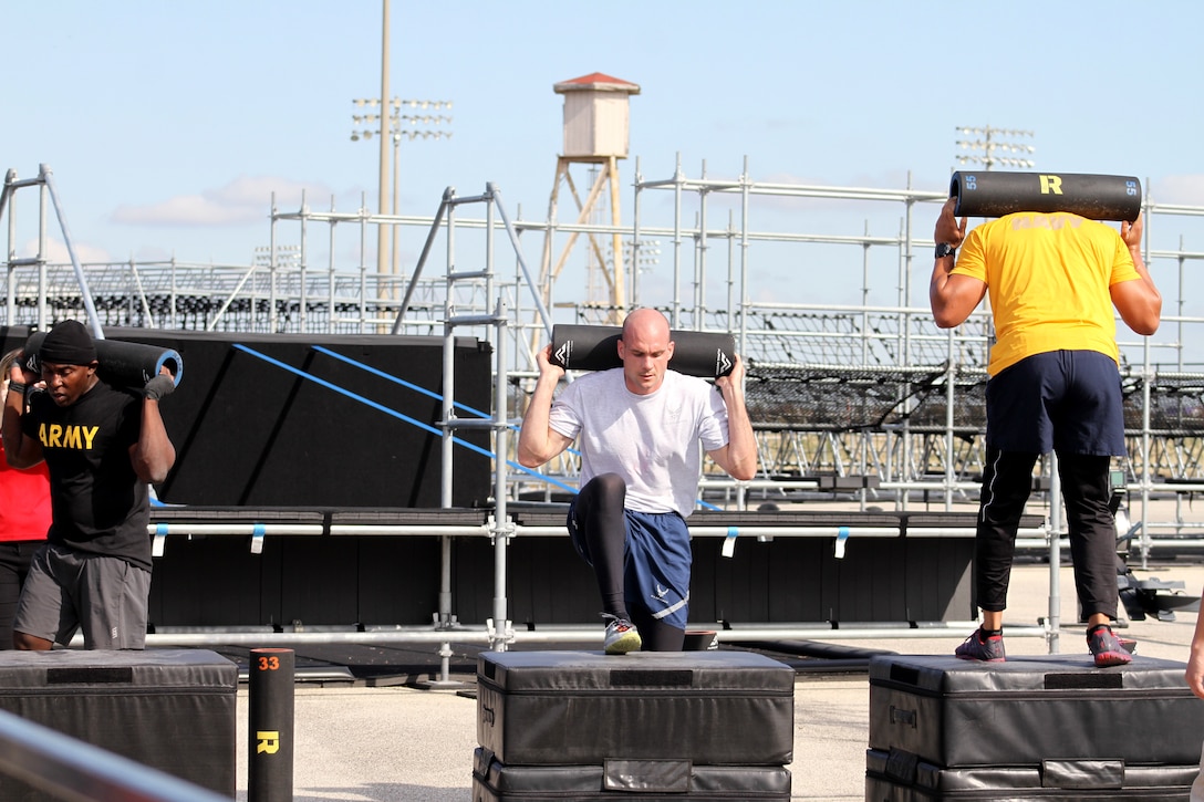 From left, Army Sgt. 1st Class Ken Huguley, Air Force 1st Lt. John Novotny and Navy Senior Chief Petty Officer Josh Husband are neck and neck at one of the strength obstacles during the first Inter-service Alpha Warrior Final Battle Nov. 17, 2018, Retama Park, Selma, Texas. (U.S. Air Force photo by Debbie Aragon)