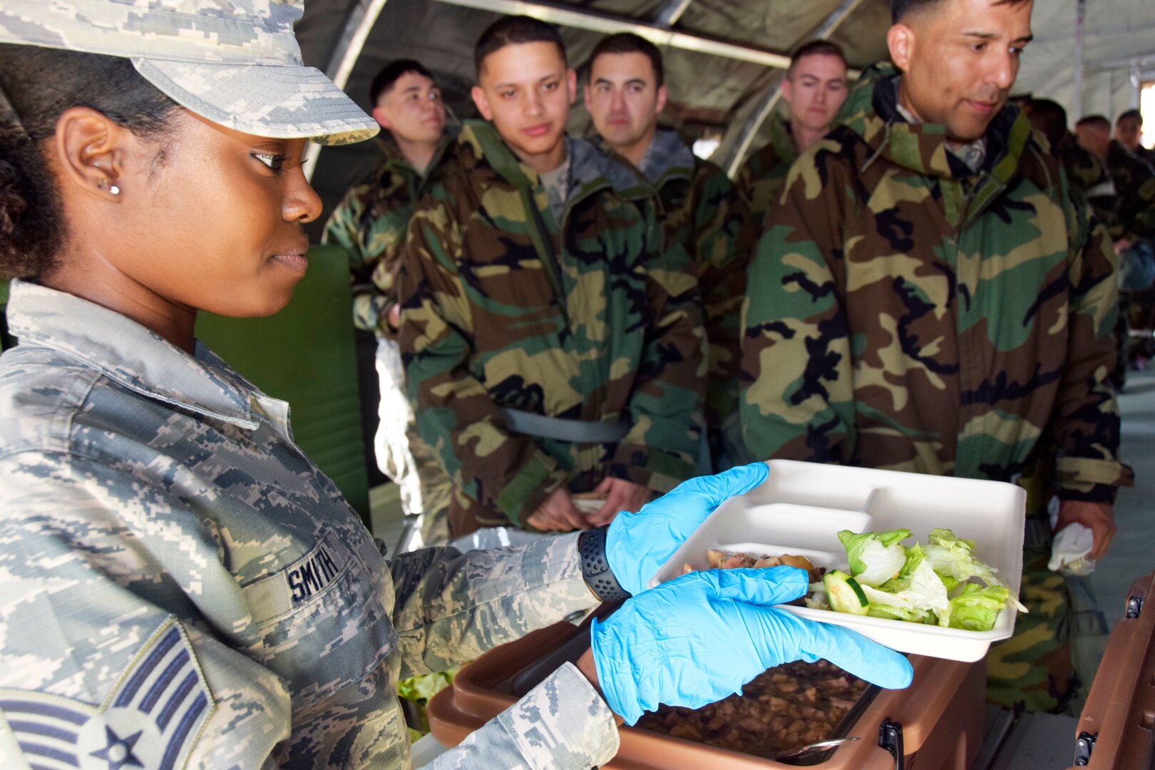 Staff Sgt. Chelsea L. Smith, 433rd Force Support Squadron fitness specialist, helps serve meals to other Alamo Alpha exercise participants in a single pallet expeditionary kitchen during a wing-wide readiness exercise at Joint Base San Antonio-Lackland, Texas Nov. 17, 2018.