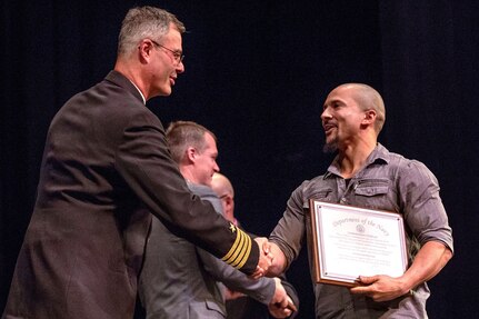 PSNS commander Capt. Howard B. Markle congratulates shipfitter Tao Smith during the PSNS Apprenticeship Class of 2018 graduation ceremony Friday, Nov. 16 at Bremerton High School in Bremerton. The ceremony celebrated 270 graduates who earned a journey-level certificate in one of 26 trades and an associate degree in technical arts.