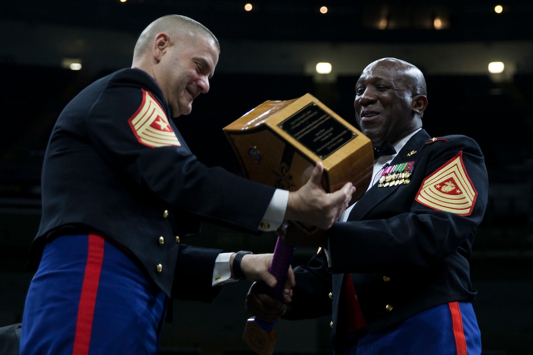 Sgt. Maj. Scott D. Grade, left, sergeant major of Marine Forces Reserve and Marine Forces North presents a gift to the guest of honor, Sgt. Maj. Ronald L. Green, sergeant major of the Marine Corps, right, during the 243rd annual Marine Corps birthday ball at the Mercedes-Benz Superdome New Orleans, on Nov. 16, 2018. Every year, a birthday ball is hosted celebrating the birthday and traditions of the Marine Corps. (U.S. Marine Corps photo by Lance Cpl. Tessa D. Watts)