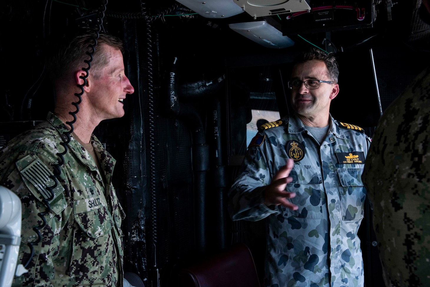 PORT MORESBY, Papua New Guinea (Nov. 16, 2018) Capt. Jon Early, commanding officer of the Royal Australian Navy landing helicopter dock ship HMAS Adelaide (L01), and Capt. Tom Shultz, commanding officer of the amphibious transport dock ship USS Green Bay (LPD 20), converse in the helicopter tower of the Green Bay during a tour. Green Bay is in Port Moresby to assist with security efforts ahead of the Asia-Pacific Economic Cooperation (APEC) conference and is the second U.S. ship to visit Port Moresby in the last two months. Green Bay is part of Amphibious Squadron 11 and is operating in the region to enhance interoperability with partners and serve as a ready-response force for any type of contingency.