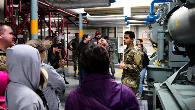 Staff Sgt. Frank Martinez, tour guide and project manager assigned to the 694th Intelligence Support Squadron, briefs families of the Airmen during a tour of the Air and Space Operations Center and Korean Combined Operations and Intelligence Center on Osan Air Base, Nov. 16, 2018.