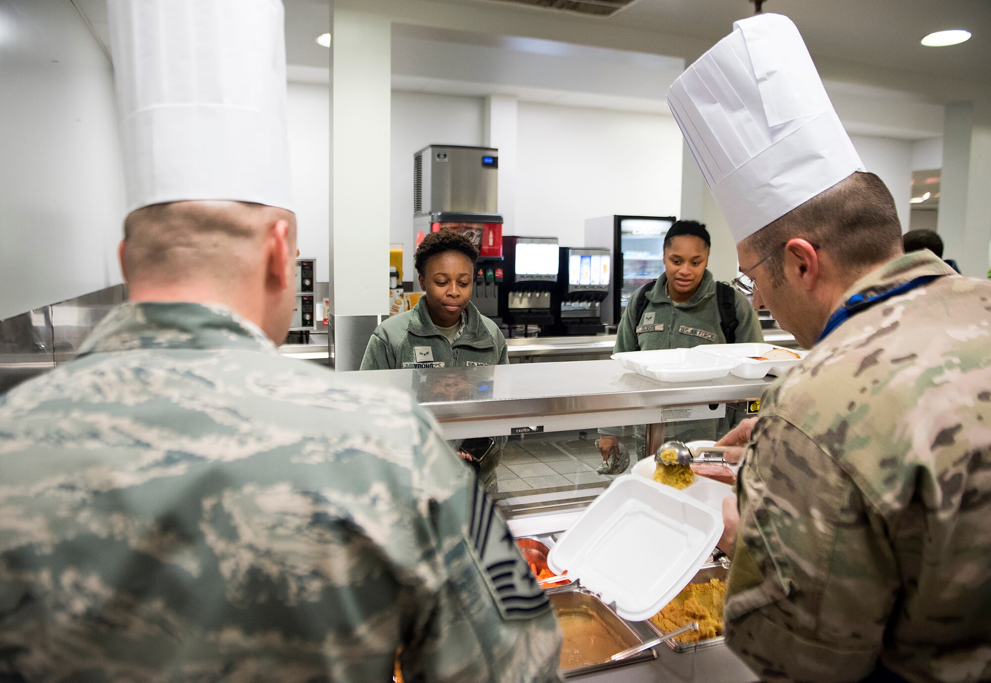 Col. Thomas P. Sherman, 88th Air Base Wing and installation commander, and Chief Master Sgt. Stephen A. Arbona, 88th ABW command chief, prepare a Thanksgiving dinner to go for Airman 1st Class Danyai Young, 88th Force Support Squadron personnel specialist, in the Wright-Patterson Air Force Base, Ohio, dining facility Nov. 15, 2018. Wright-Patt leadership served airmen Thanksgiving dinner a week early since many will be traveling on Thanksgiving. (U.S. Air Force photo by R.J. Oriez)