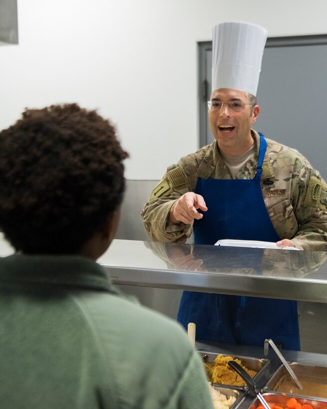 Col. Thomas P. Sherman, 88th Air Base Wing  and installation commander, asks Airman 1st Class Danyai Young, 88th Force Support Squadron personnel specialist, what she would like for Thanksgiving dinner as he prepares her plate in the Wright-Patterson Air Force Base, Ohio, dining facility Nov. 15, 2018. Various members of the Wright-Patt leadership took turns serving dinner to the Airmen eating in the facility. (U.S. Air Force photo by R.J. Oriez)
