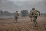 U.S. Army M109 Paladin artillery crew-members race into their gun after pulling the initial round from a 50-ft. lanyard during NATO joint training exercise, Anakonda-18 (AN-18), at Bemowo Piskie Training Area, Poland, Nov. 14. AN-18 is a 10-day log training exercise designed to strengthen the interoperability between participating nations by developing strategies in defensive operations and execution to better prepare against any form of threat against NATO allies.