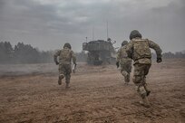 U.S. Army M109 Paladin artillery crew-members race into their gun after pulling the initial round from a 50-ft. lanyard during NATO joint training exercise, Anakonda-18 (AN-18), at Bemowo Piskie Training Area, Poland, Nov. 14. AN-18 is a 10-day log training exercise designed to strengthen the interoperability between participating nations by developing strategies in defensive operations and execution to better prepare against any form of threat against NATO allies.