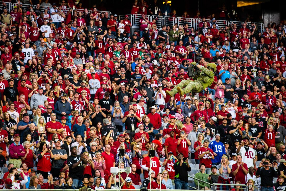 An Airman assigned to the 306th Rescue Squadron, Davis-Monthan Air Force Base, Ariz., uses an Atlas device to climb out of State Farm Stadium in front of thousands of fans, Nov. 18, 2018 at Glendale, Ariz.