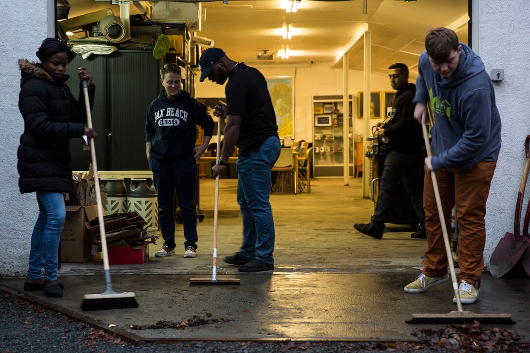 Sailors sweep the garage of the Veterans Moter Veterans Home in Oslo, Norway Nov. 15, 2018. Marines and Sailors with the 24th Marine Expeditionary Unit and USS Iwo Jima (LHD 7) assisted in general maintenance, constructed a toy shelf and built relationships with Norwegian veterans. The service members volunteered their time during a port visit in Oslo to assist the needs of the local community. (U.S. Marine Corps photo by Cpl. Margaret Gale)