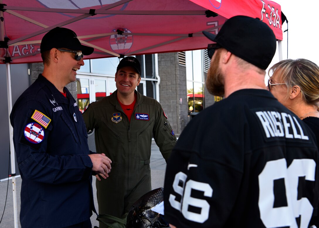 Master Sgt. Robert Garner, F-35A Lightning II Heritage Flight Team chief, and Capt. Andrew “Dojo” Olson, F-35A Lightning II Heritage Flight Team commander, speak with football fans at the Arizona Cardinals Salute to Service game, Nov. 18, 2018, at State Farm Stadium, Glendale, Ariz.