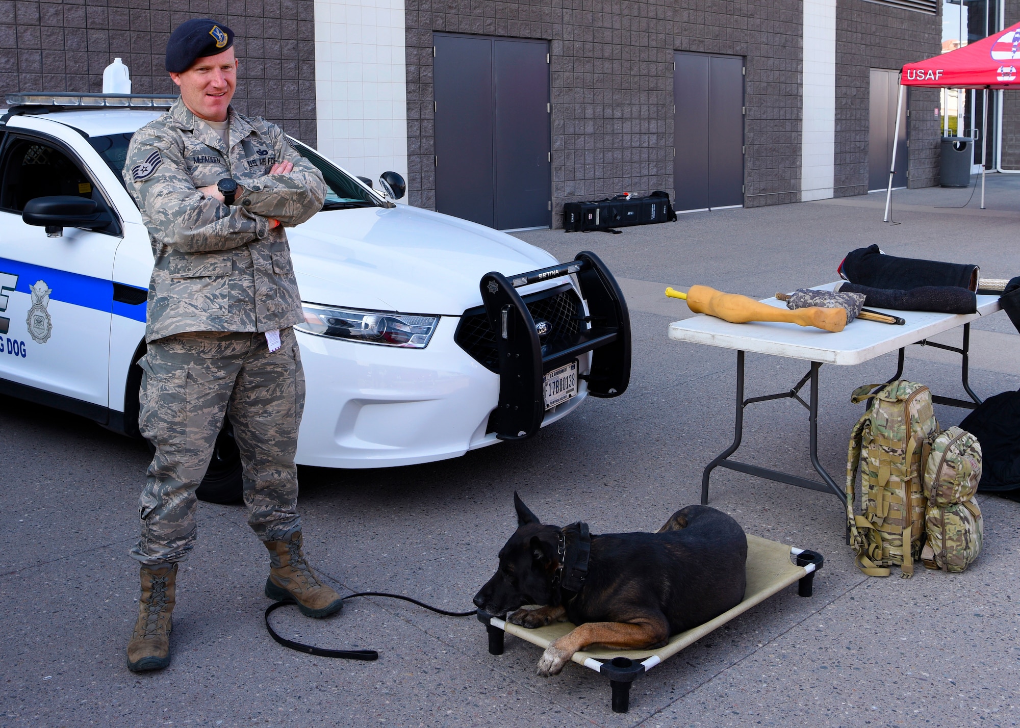 Staff Sgt. Sean McFadden, 56th Security Forces Squadron military working dog trainer, next to MWD Rango before the Arizona Cardinals Salute to Service game, Nov. 18, 2018, at State Farm Stadium, Glendale, Ariz.