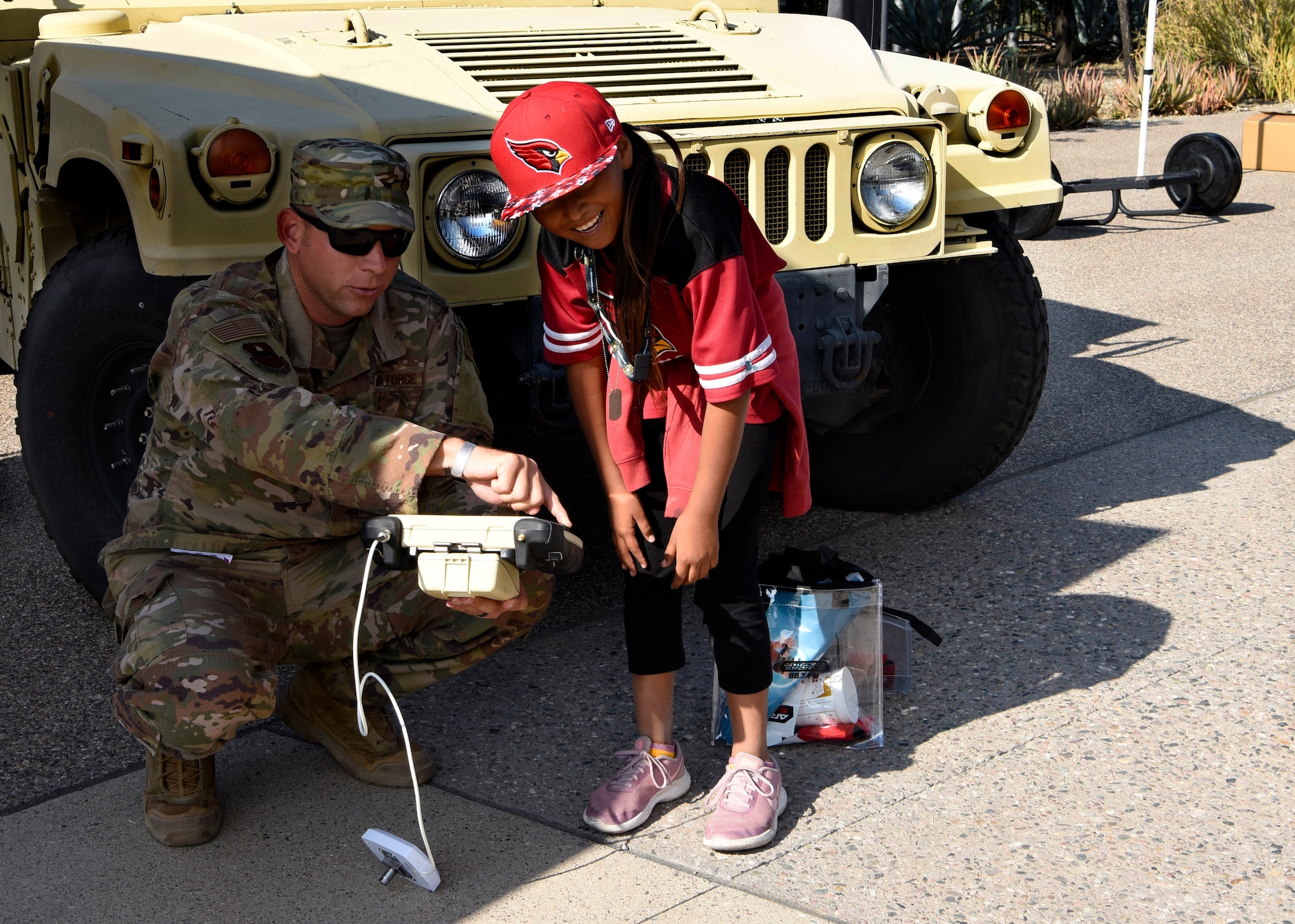 Tech. Sgt. Shane Bridges, 56th Civil Engineer Squadron Explosive Ordnance Disposal Airman, shows a young football fan how to operate an EOD robot before the Arizona Cardinals Salute to Service game, Nov. 18, 2018, at State Farm Stadium, Glendale, Ariz.