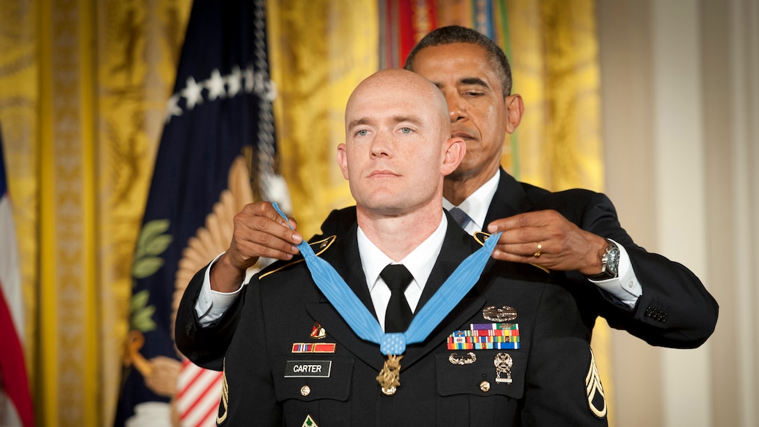 President Barack Obama places the Medal of Honor around a soldier's neck.