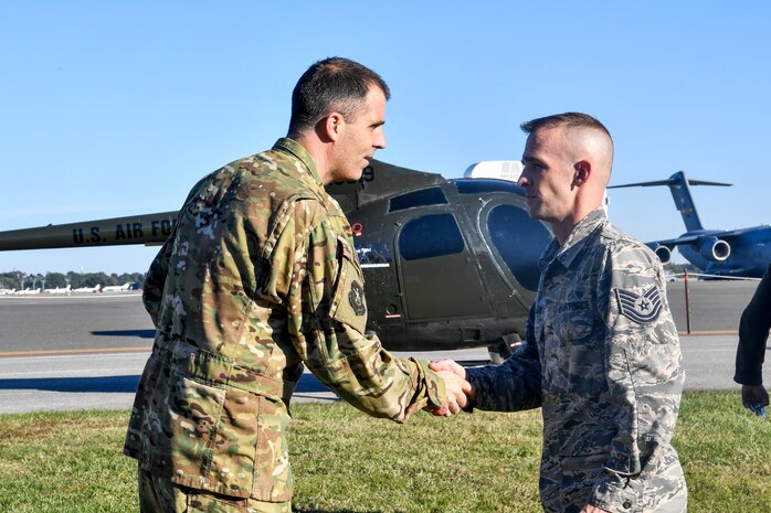 Tech. Sgt. James Moreland, 437th Maintenance Squadron metals technologist, receives a coin for helping refurbish a donated training helicopter for the 437th Operations Group special operations unit, Nov. 16, 2018, at Joint Base Charleston, S.C.