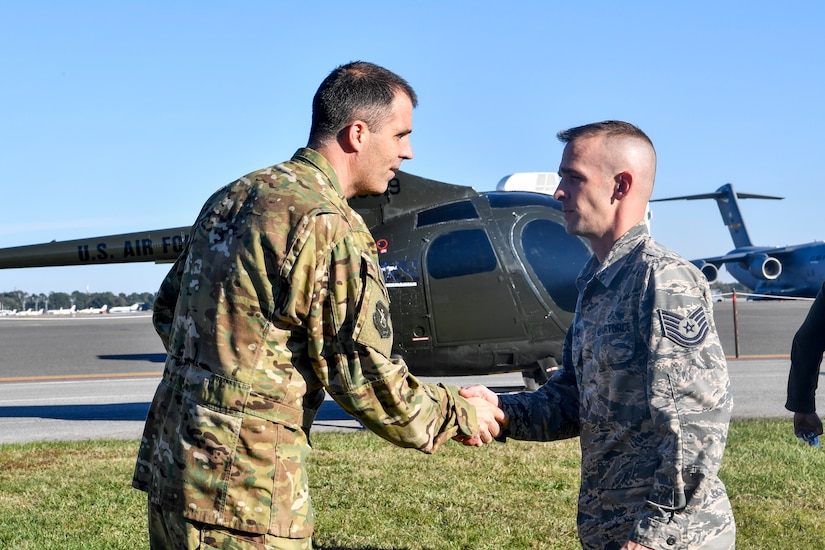 Tech. Sgt. James Moreland, 437th Maintenance Squadron metals technologist, receives a coin for helping refurbish a donated training helicopter for the 437th Operations Group special operations unit, Nov. 16, 2018, at Joint Base Charleston, S.C.
