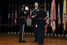 FORT KNOX, Ky. - Command Sgt. Maj. Jason Willett, senior enlisted advisor, 1st Theater Sustainment Command, receives a final salute as a Soldier while holding his Army retirement flag, Oct. 23. Willett dedicated 26 years to service in the Army, caring for the Army's greatest assets - its Soldiers. (U.S. Army photos by Spc. Zoran Raduka)