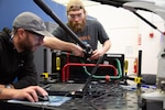 Timothy Healy and Douglas Gualteire, Portsmouth Naval Shipyard, learn how to use a portable coordinate measuring machine during a training session coordinated and taught by Puget Sound Naval shipyard and Intermediate Maintenance Facility employees.