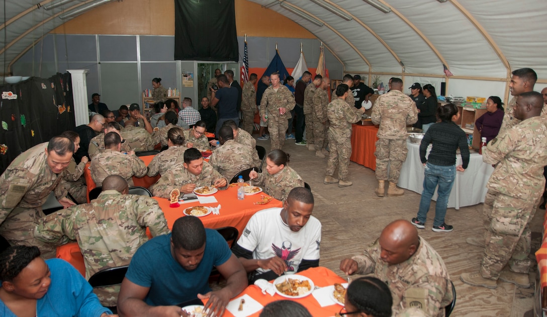 U.S. Soldiers of the 369th Sustainment Brigade eat a Thanksgiving holiday meal at Camp Arifjan, Kuwait Nov. 26, 2016.