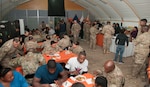 U.S. Soldiers of the 369th Sustainment Brigade eat a Thanksgiving holiday meal at Camp Arifjan, Kuwait Nov. 26, 2016.