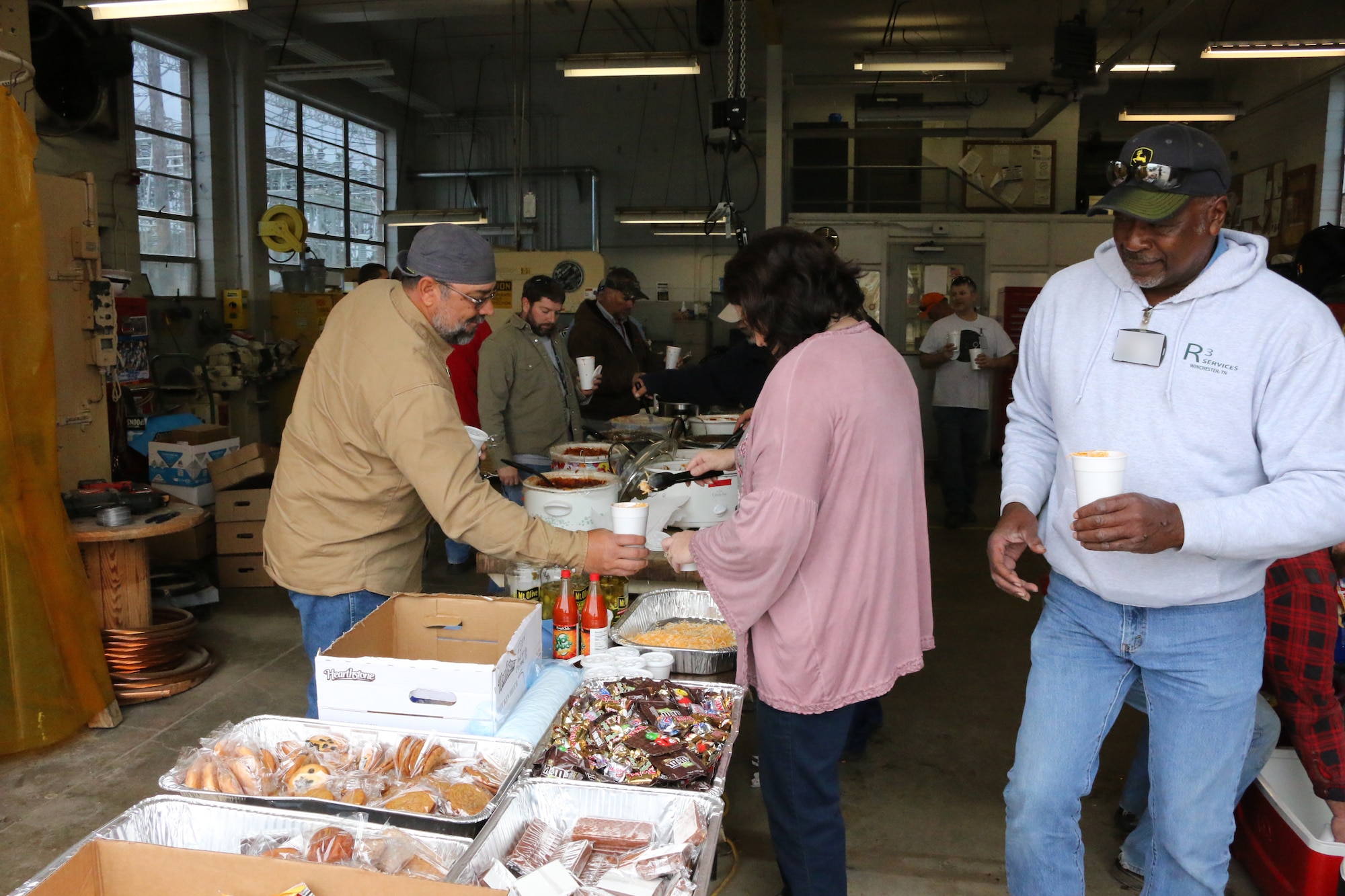 Personnel at Arnold Air Force Base enjoy some good food for a good cause during a chili sale held as part of the “International Brotherhood of Electrical Workers Kids for Christmas” fundraiser, which raises money to purchase Christmas gifts for area foster children. The Nov. 2 event, held at the Arnold AFB Power Control building, was widely attended by those on base. (U.S. Air Force photos by Bradley Hicks) (Image was altered by obscuring badges for security purposes)