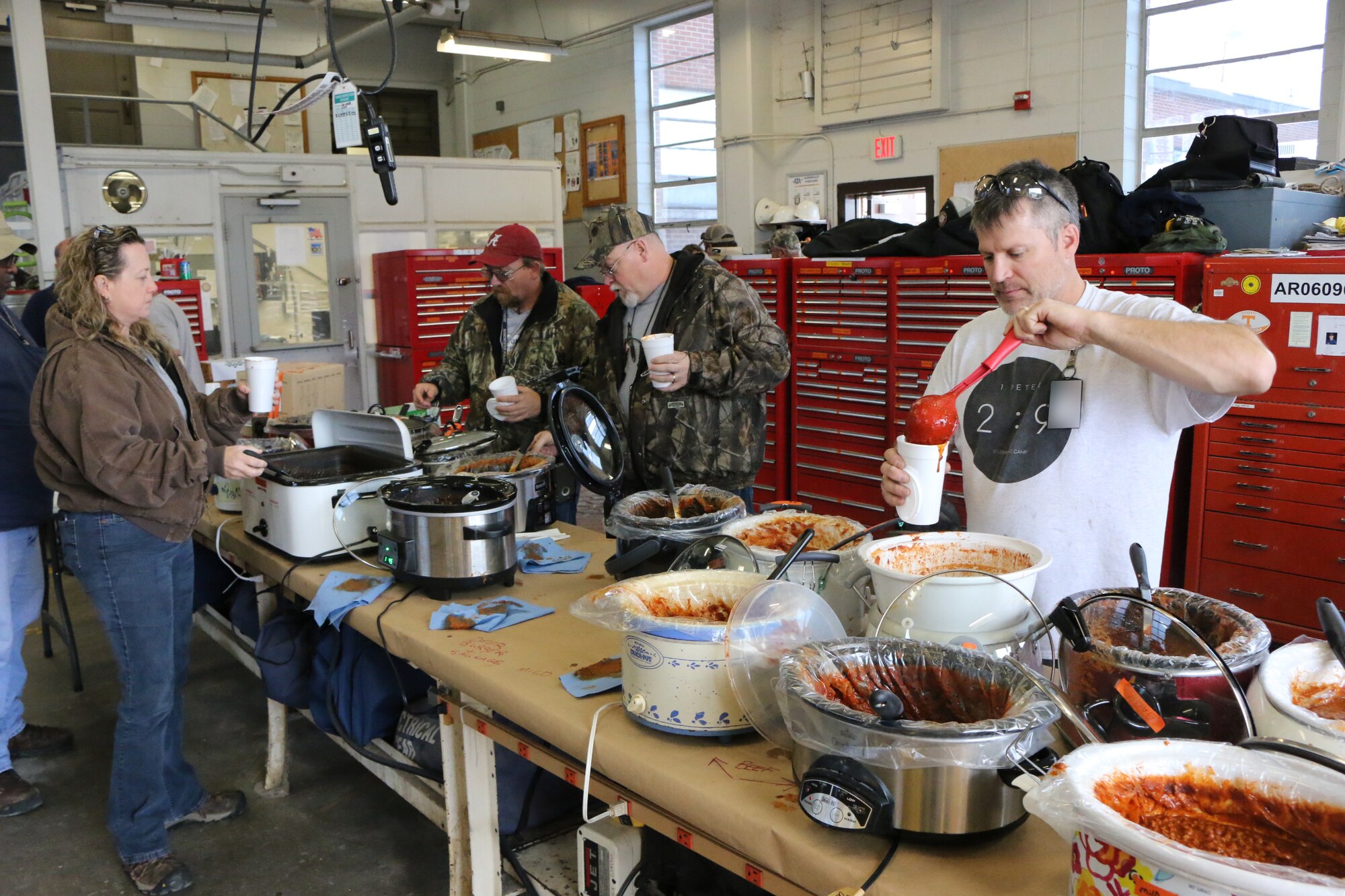 Personnel at Arnold Air Force Base enjoy some good food for a good cause during a chili sale held as part of the “International Brotherhood of Electrical Workers Kids for Christmas” fundraiser, which raises money to purchase Christmas gifts for area foster children. The Nov. 2 event, held at the Arnold AFB Power Control building, was widely attended by those on base. (U.S. Air Force photos by Bradley Hicks) (Image was altered by obscuring badges for security purposes)