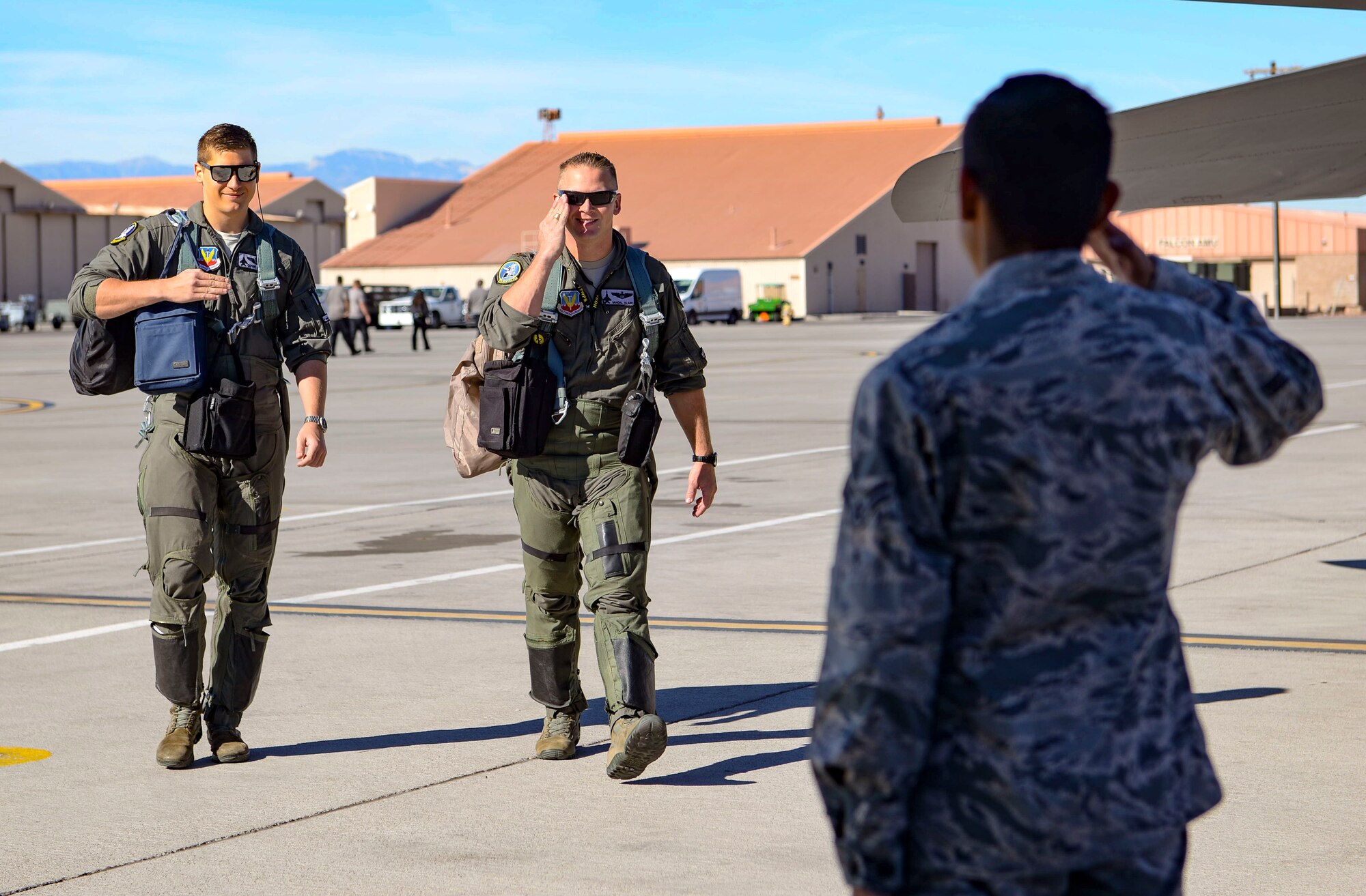 Airman 1st Class Bonifacio Garcia, 757th Aircraft Maintenance Squadron Strike Aircraft Maintenance Unit F-15E Strike Eagle fighter jet maintainer, salutes Maj. Travis Klare and Capt. Andrew Griffin, 17th Weapons Squadron pilots, before their flight Nov. 15, 2018 at Nellis Air Force Base, Nevada. The pilots flew their F-15E over the Nevada Test and Training Range during a Gunsmoke Competition. (U.S. Air Force photo by Airman Bailee A. Darbasie)