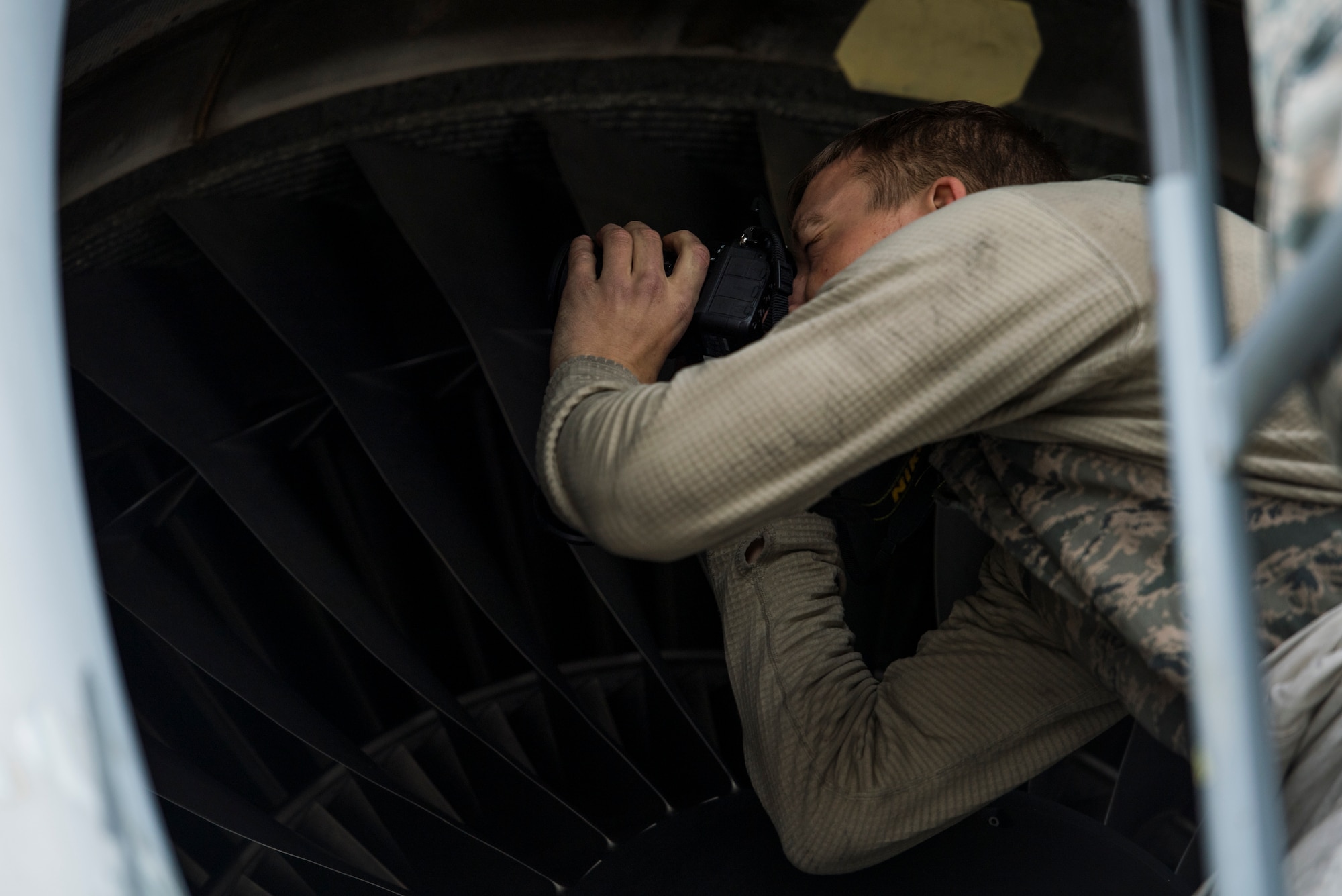 U.S. Air Force Senior Airman Clark Dewhitt, 721st Aircraft Maintenance Squadron propulsions journeyman, takes a photo of damage on a C-17 Globemaster III engine on Ramstein Air Base, Germany Oct. 31, 2018.