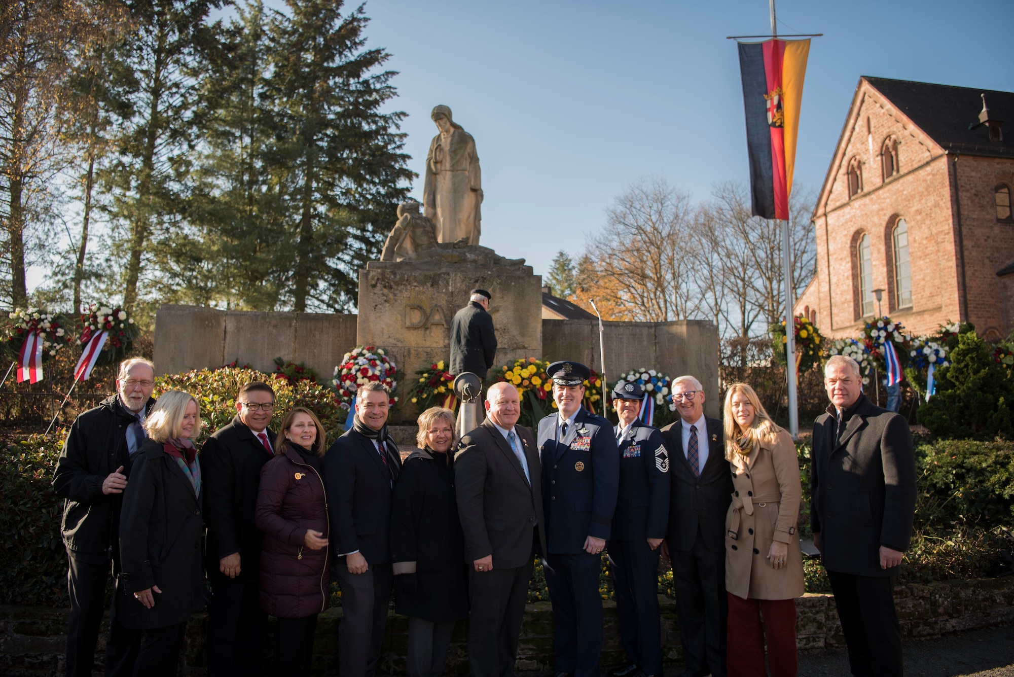 U.S. Air Force Brig. Gen. Mark R. August, 86th Airlift Wing commander, poses with Ralf Hechler, Ramstein-Miesenbach mayor, and other representatives who participated in Germany’s National Day of Mourning in Ramstein-Miesenbach, Nov. 18, 2018. The German National Day of Mourning honors all victims of war and persecution, and is the German equivalent of America’s Memorial Day.