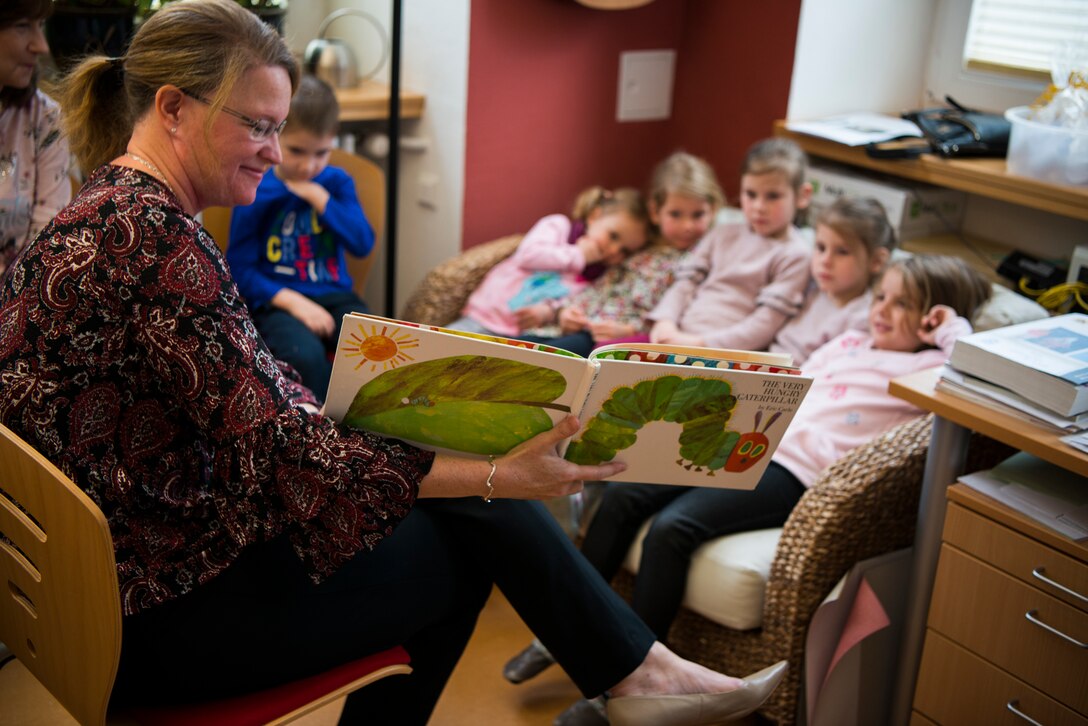 Cris August, spouse of U.S. Air Force Brig. Gen. Mark August, 86th Airlift Wing commander, reads a book to German children during an 86th Airlift Wing Host Nation grassroots program trip in Dansberg Germany, Nov. 20, 2018. The 86th AW Host Nation office is the liaison between the local community and Ramstein, and the grassroots program helps improve relations between the two. (U.S. Air Force photo by Airman 1st Class Noah Coger)