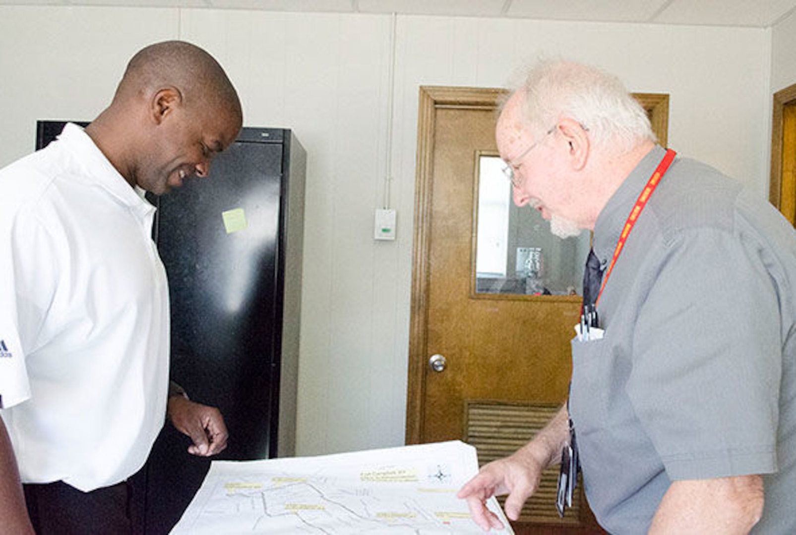 Two gentlemen discuss a map