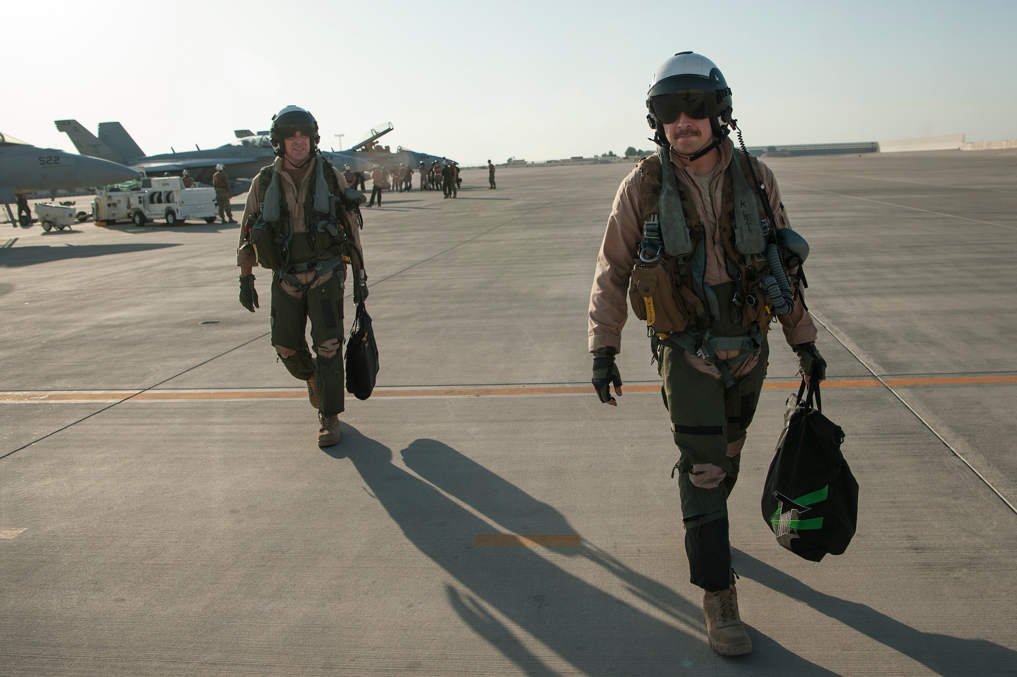 U.S. Navy Cmdr. Steve Shauberger (left), Electronic Attack Squadron 135 (VAQ-135) “Black Ravens” commander, and U.S. Air Force 1st Lt. Jonathan Wright, 390th Electronic Combat Squadron and VAQ-135 EA-18G Growler pilot, make their way across the flightline after Wright’s first combat flight Nov. 19, 2018, at Al Udeid Air Base, Qatar. Wright is the first Air Force pilot to operate a Growler during a combat mission. VAQ-135 is deployed to the U.S. 5th Fleet area of operations in support of naval operations to ensure maritime stability and security in the Central Region, connecting the Mediterranean and the Pacific through the western Indian Ocean and three strategic choke points. (U.S. Air Force photo by Tech. Sgt. Christopher Hubenthal)