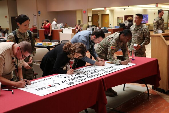 Brooke Army Medical Center staff members sign a banner of support for Clear Lake Regional Medical Center in Webster, Texas, as part of the commemoration ceremony Nov. 5, the one-year anniversary of the Sutherland Springs shooting. Clear Lake Regional Medical Center received eight patients – all students – in the wake of the Santa Fe High School Shooting last May. BAMC wanted to “pay it forward” to another hospital that cared for victims after a mass shooting. After the Sutherland Springs shooting, BAMC received a banner from Sunrise Hospital in Las Vegas as a demonstration of support and appreciation for our staff. Sunrise Hospital received nearly 200 victims after the Vegas shooting.