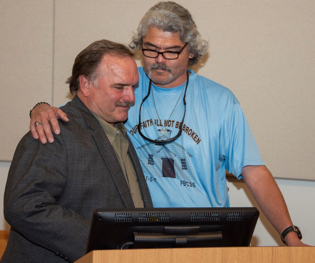 Juan “Gunny” Macias (right) hugs David Colbath (left) during a ceremony Nov. 8 at Brooke Army Medical Center. Macias and Colbath both survived the mass shooting in Sutherland Springs, Texas, Nov. 5, 2017. They both recovered from their injuries at BAMC along with 6 others who were injured during the shooting.